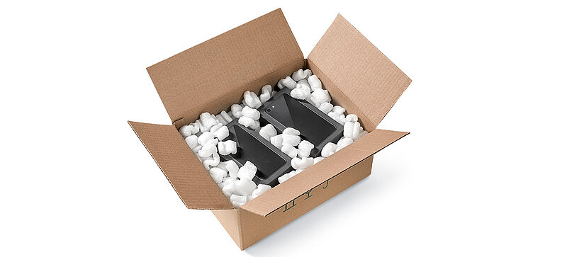 Kartonová krabice se smartphony a bioplastovým sypkým polstrováním ve tvaru písmene S