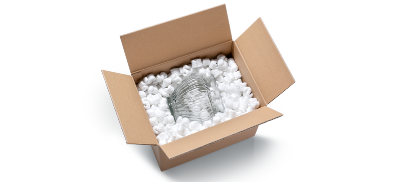 Kartonová krabice se skleněnou vázou a bílým sypkým polstrováním ve tvaru písmene S