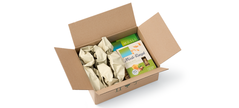 Kartonová krabice s krabičkou müsli a pásy papírových polštářů vyrobených z papíru z trávy