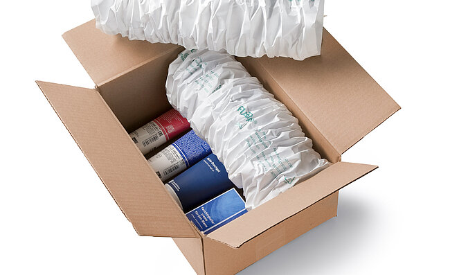 Kartonová krabice s kosmetikou a bílými papírovými polštáři