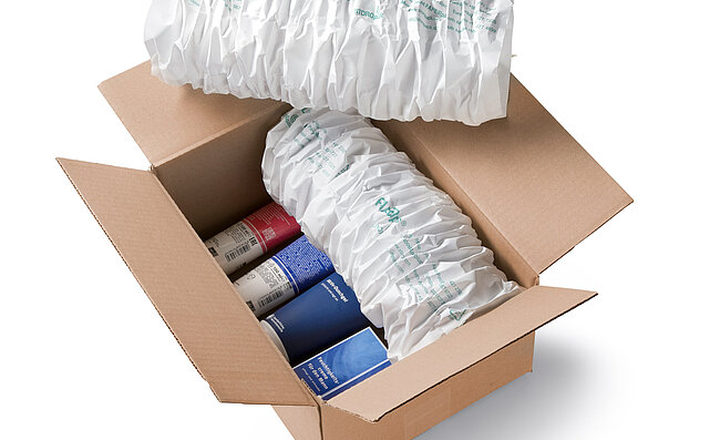 Kartonová krabice s kosmetikou a bílými papírovými polštáři