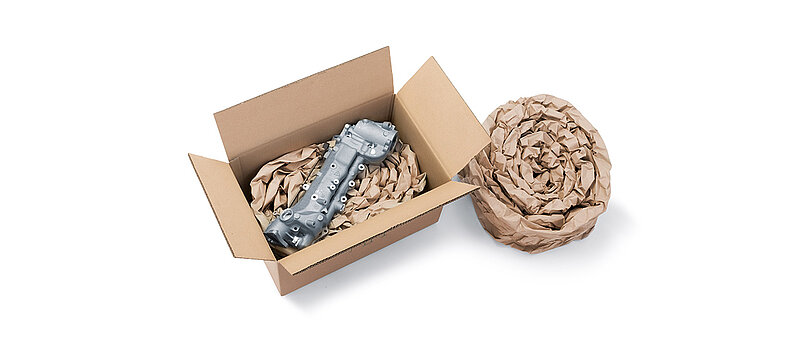 Kartonová krabice se součástkou a papírové polstrování vyrobené ze srolovaných pásů papírových polštářů