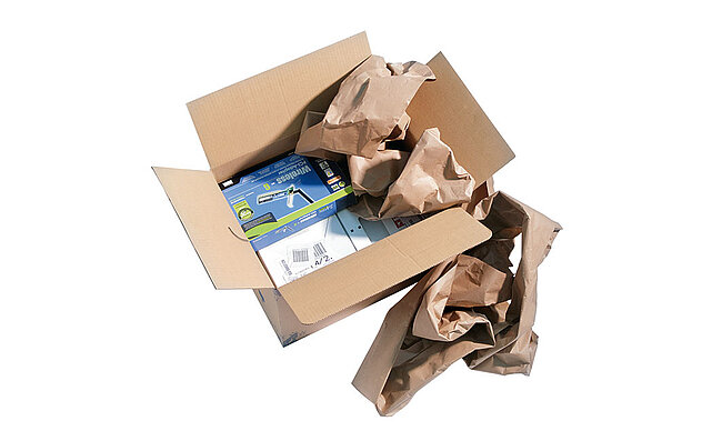 Kartonová krabice s technickými zařízeními a hnědými papírovými polštáři