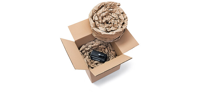 Kartonová krabice se součástkou a papírové polstrování vyrobené ze srolovaných pásů papírových polštářůrängen